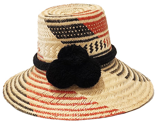 "Colorful handmade hats by Wuitusu, crafted from Iraca palm fibers by the Wayuu tribe, adorned with cultural pompoms."