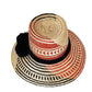 Colorful handmade straw hat by Wuitusu, woven from Iraca palm fibers, adorned with symbolic pompoms.