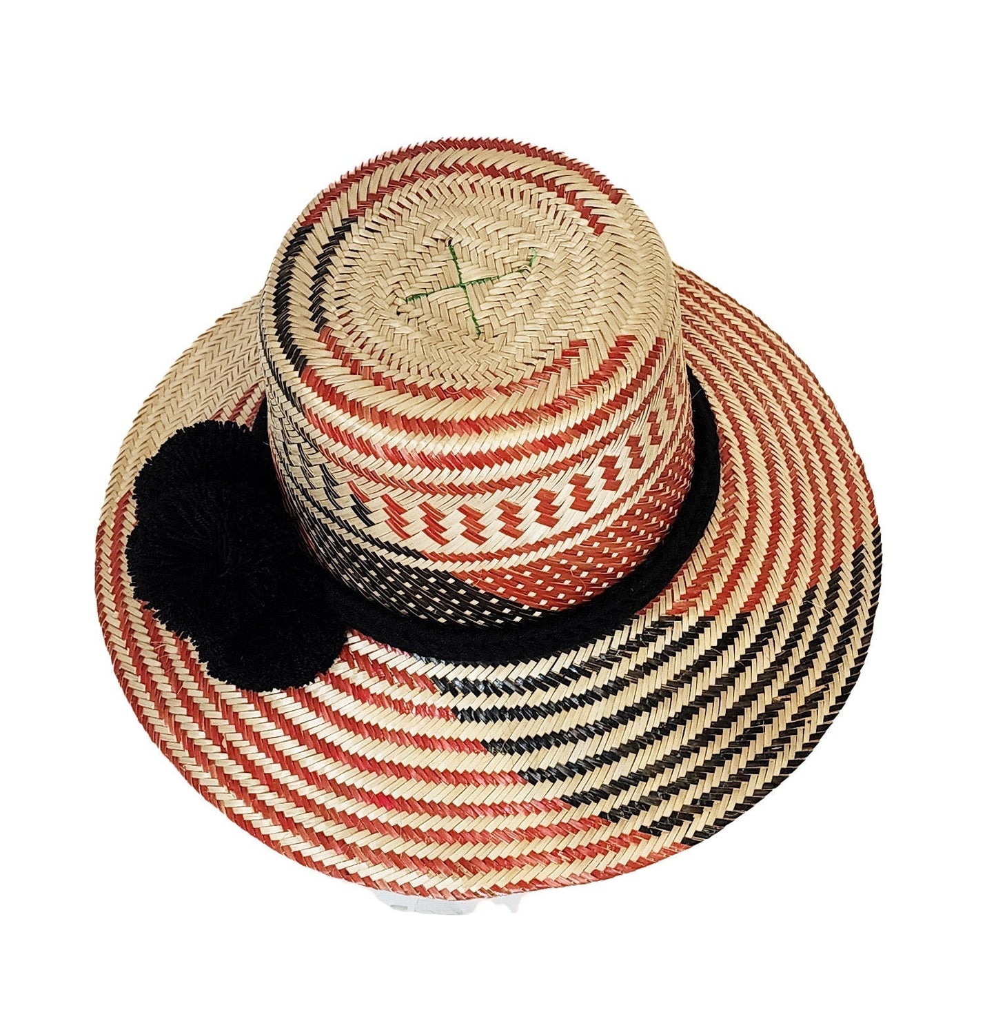 "Colorful, handmade straw hats by Wayuu tribe with adjustable sizes and meaningful pompoms, showcasing unique craftsmanship."