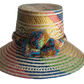 "Colorful handmade Wayuu hat by Wuitusu, crafted from Iraca palm fibers, adorned with culturally significant pompoms."