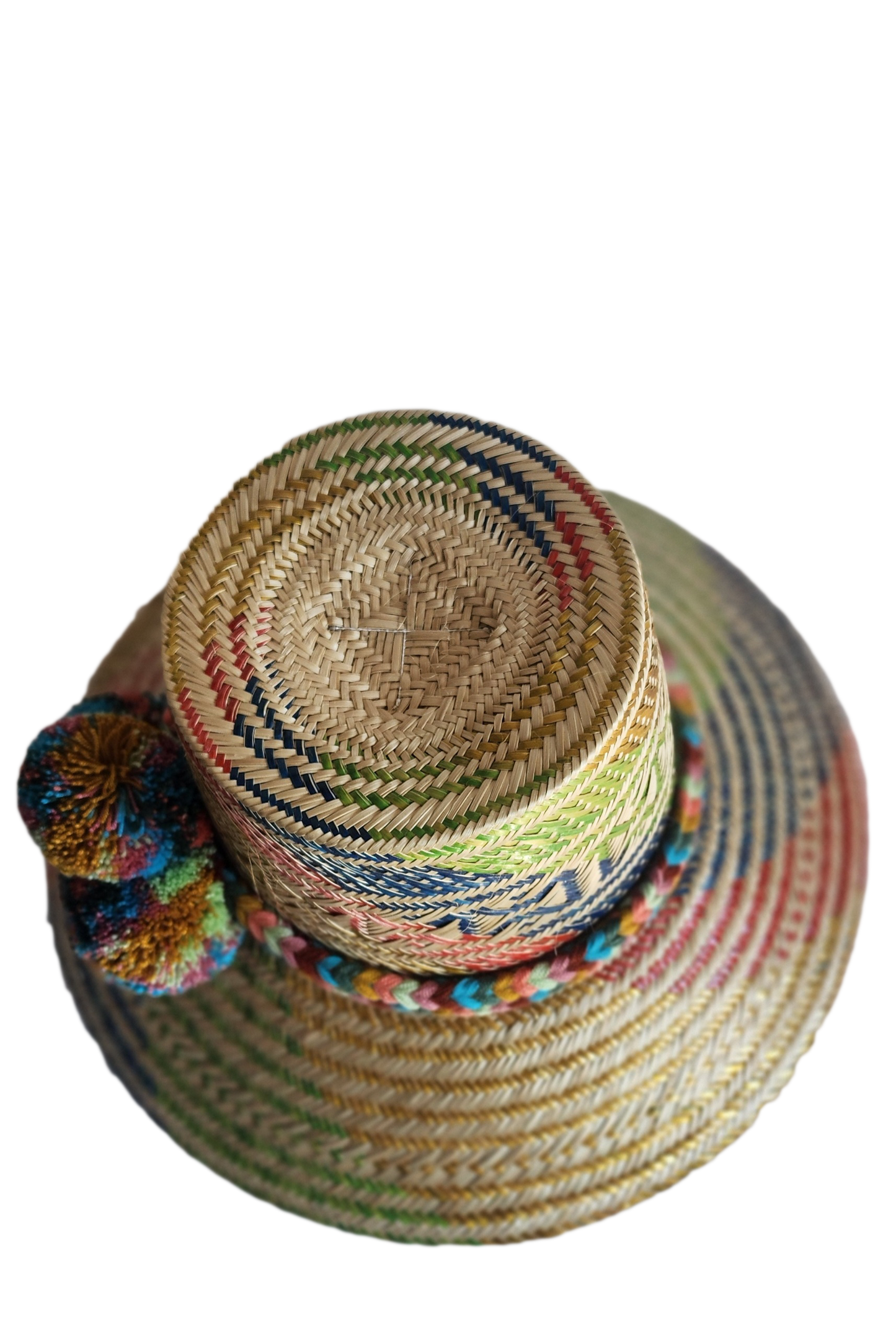 "Colorful handmade Wayuu hat by Wuitusu, crafted from Iraca palm fibers, adorned with culturally significant pompoms."