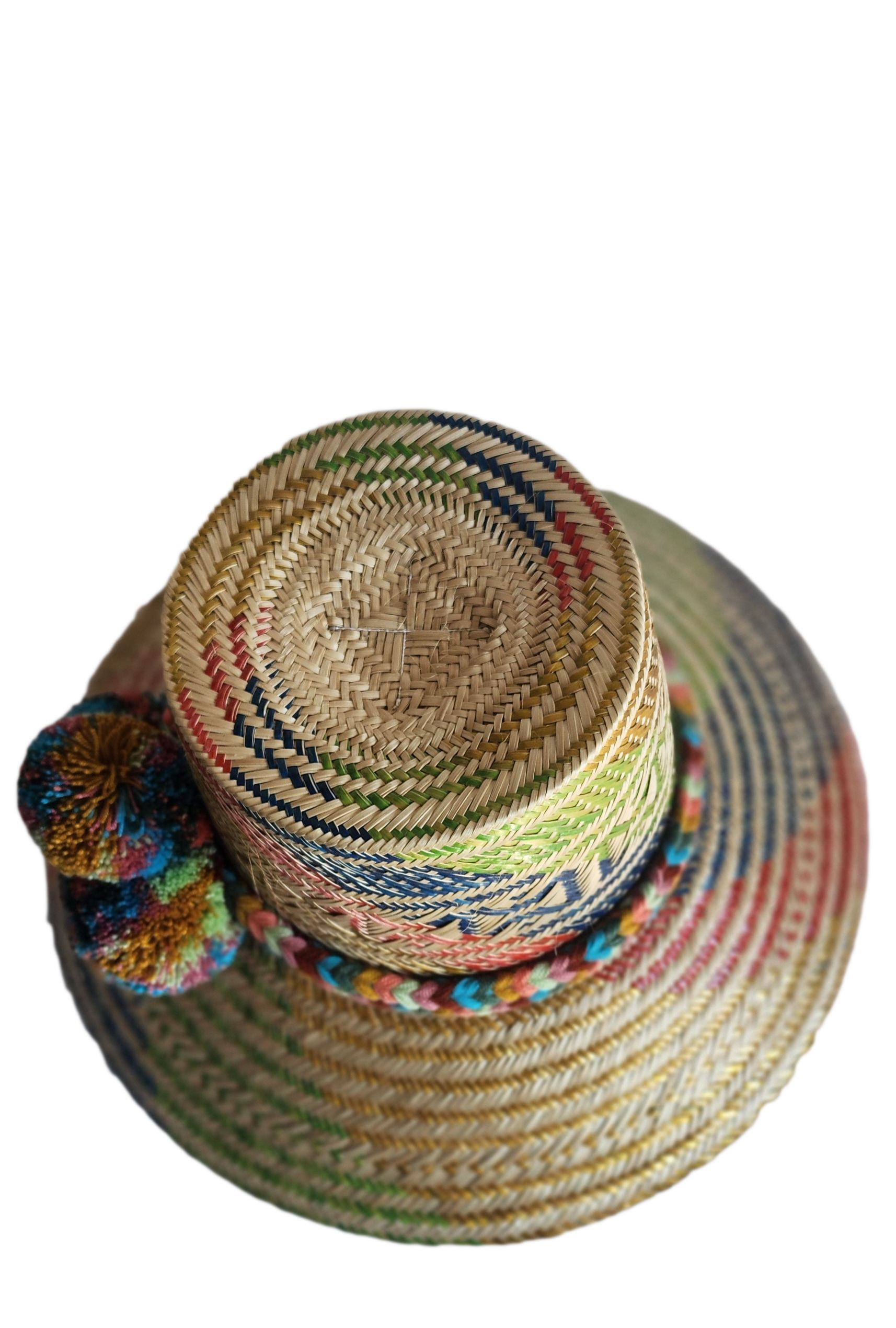 "Colorful handmade Wayuu hat by Wuitusu, crafted from Iraca palm fibers, adorned with culturally significant pompoms."
