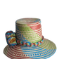 "Colorful handmade Wayuu hat crafted from Iraca palm, featuring adjustable size and cultural pompoms, supporting Wayuu artisa
