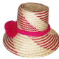 "Colorful handmade Wayuu hat crafted from Iraca palm fiber, adorned with significant pompoms, from Colombia and Venezuela."