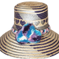 "Colorful handmade Wayuu hat crafted from Iraca palm fibers, adorned with meaningful pompoms, offering unique style and sun p