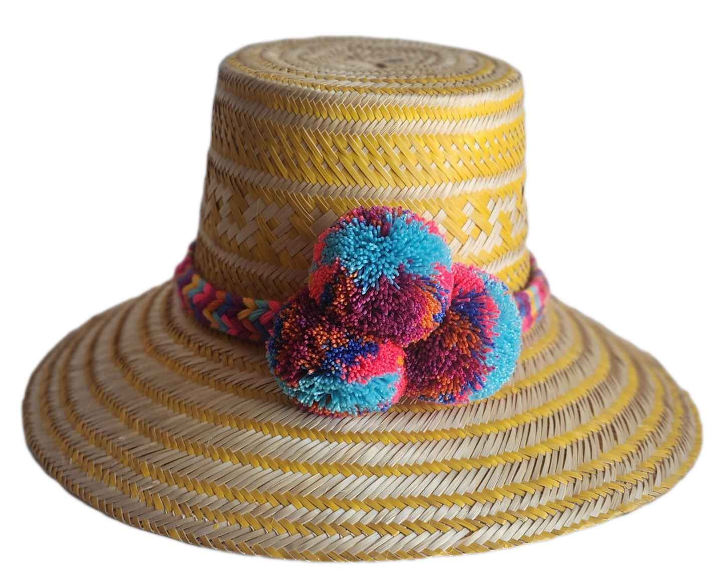 "Colorful handmade Wayuu hat crafted from Iraca palm fibers, adorned with significant pompoms, showcasing artisan craftsmansh