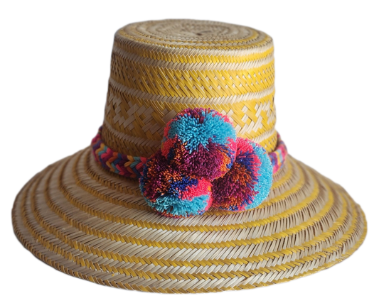 "Colorful handmade Wayuu hat crafted from Iraca palm fibers, adorned with significant pompoms, showcasing artisan craftsmansh