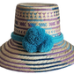 "Colorful handmade Wayuu hat crafted from Iraca palm fibers, adorned with meaningful pompoms, adjustable fit."