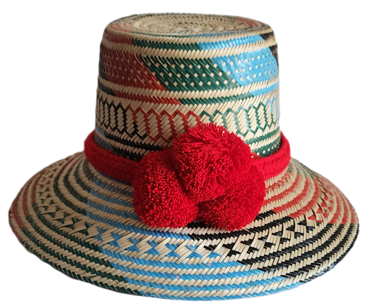 "Colorful handmade Wayuu hat crafted from Iraca palm fibers, adorned with significant pompoms, and adjustable for a perfect f