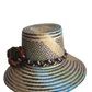"Colorful handmade Wayuu hat crafted from Iraca palm fibers, adorned with culturally significant pompoms, offering adjustable
