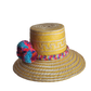 "Colorful handmade Wayuu hat crafted from Iraca palm fibers, adorned with significant pompoms, showcasing artisan craftsmansh