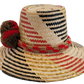 "Colorful handmade Wayuu hat crafted from Iraca palm fibers, adorned with significant cultural pom-poms for style and sun pro