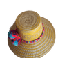 "Colorful handmade Wayuu hat crafted from Iraca palm fibers, adorned with significant pompoms, showcasing artisan craftsmansh