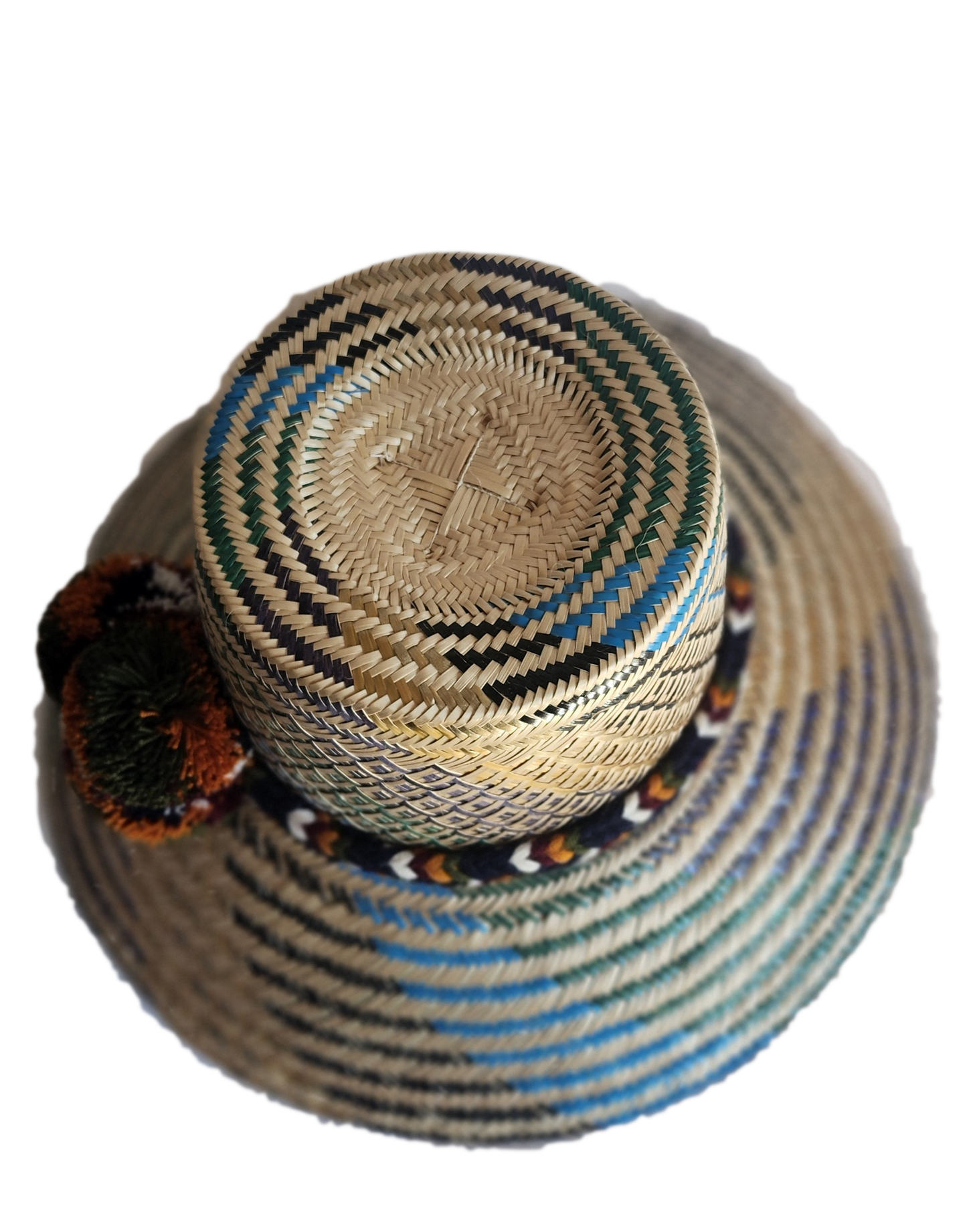 "Colorful handmade Wayuu hat crafted from Iraca palm fibers, adorned with culturally significant pompoms, offering adjustable