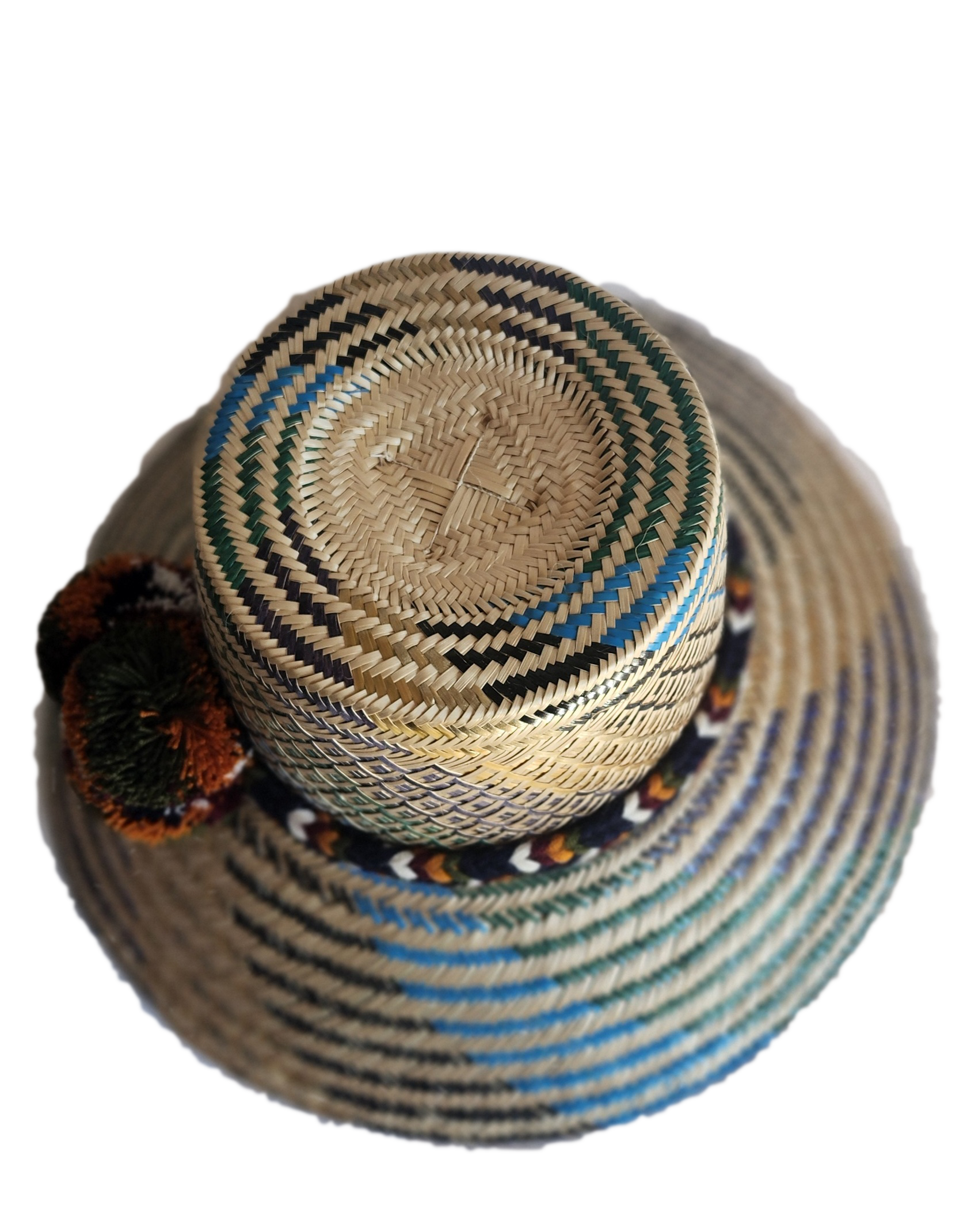 "Colorful handmade Wayuu hat crafted from Iraca palm fibers, adorned with culturally significant pompoms, offering adjustable