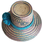 "Colorful handmade Wayuu hat crafted from Iraca palm fibers, adorned with meaningful pompoms, adjustable fit."