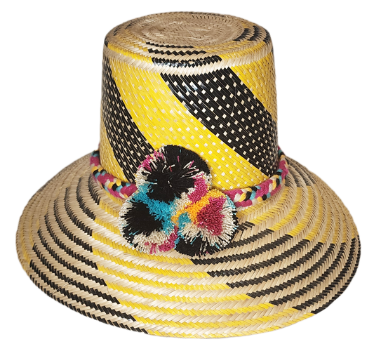 "Colorful handmade Wayuu hat crafted from Iraca palm fibers with decorative pompoms, showcasing vibrant Wayuu cultural design
