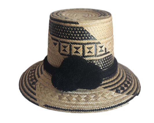 "Colorful handmade Wayuu hat crafted from Iraca palm fibers with culturally significant pompoms, offering sun protection and 