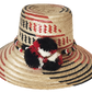 "Colorful handmade Wayuu hat crafted from Iraca palm fibers with distinctive pompoms, offering versatile style and cultural s