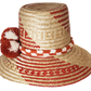"Colorful handmade Wayuu hat crafted from Iraca palm fibers with significant cultural pompoms, offering versatile styling for