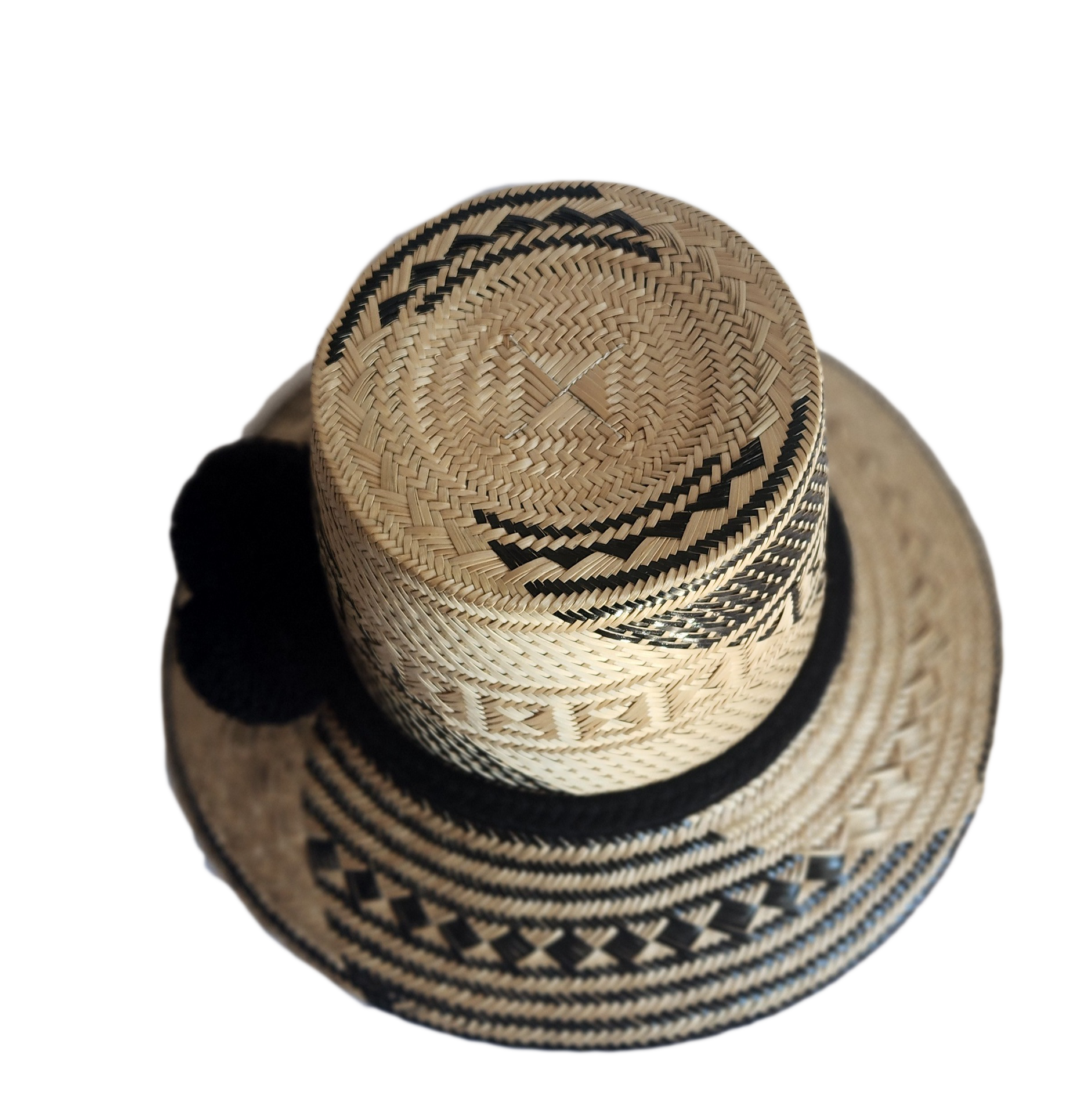 "Colorful handmade Wayuu hat crafted from Iraca palm fibers with culturally significant pompoms, offering sun protection and 