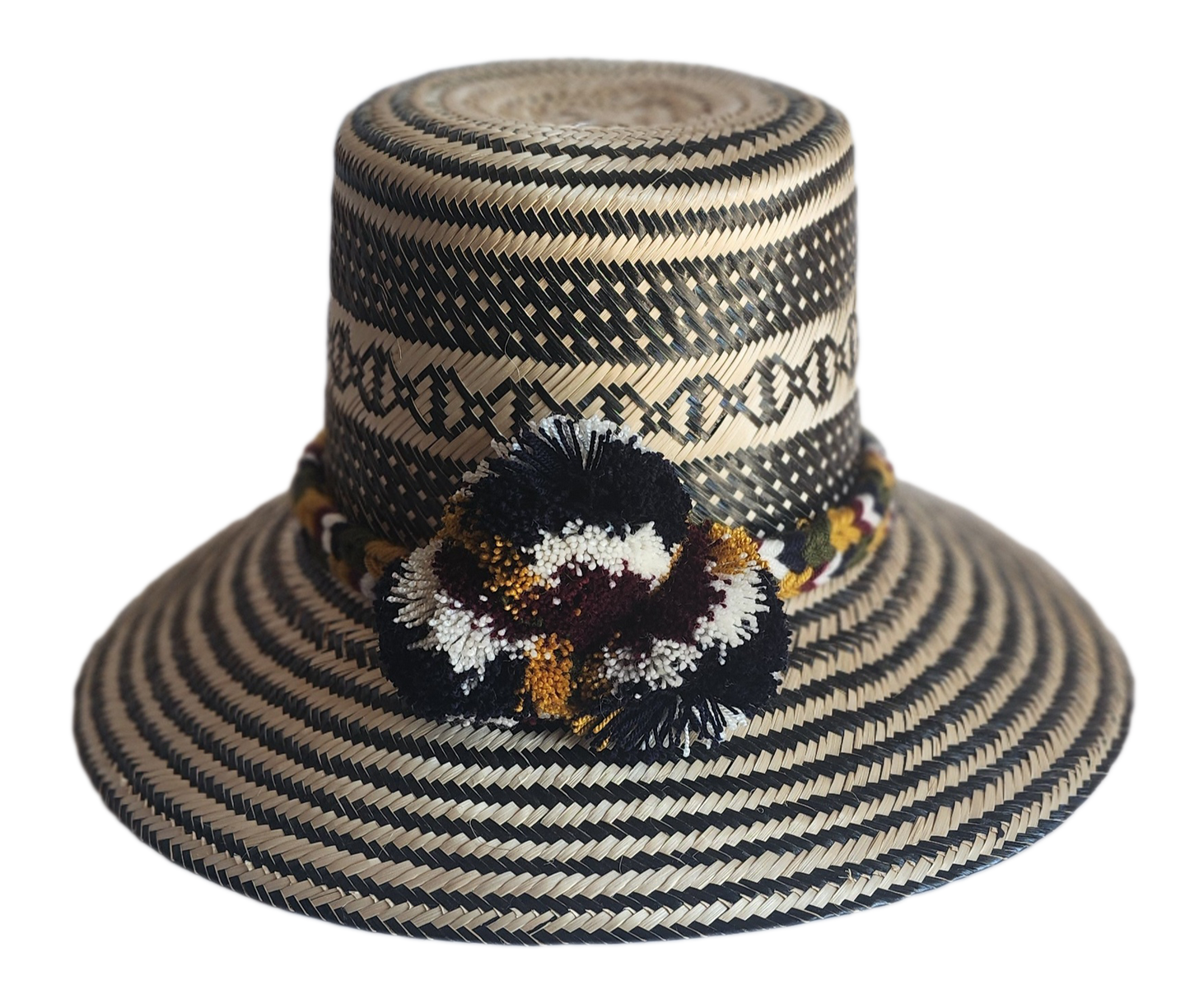 "Colorful handmade Wayuu hat crafted from Iraca palm with decorative pompoms, symbolizing wealth in Wayuu culture."