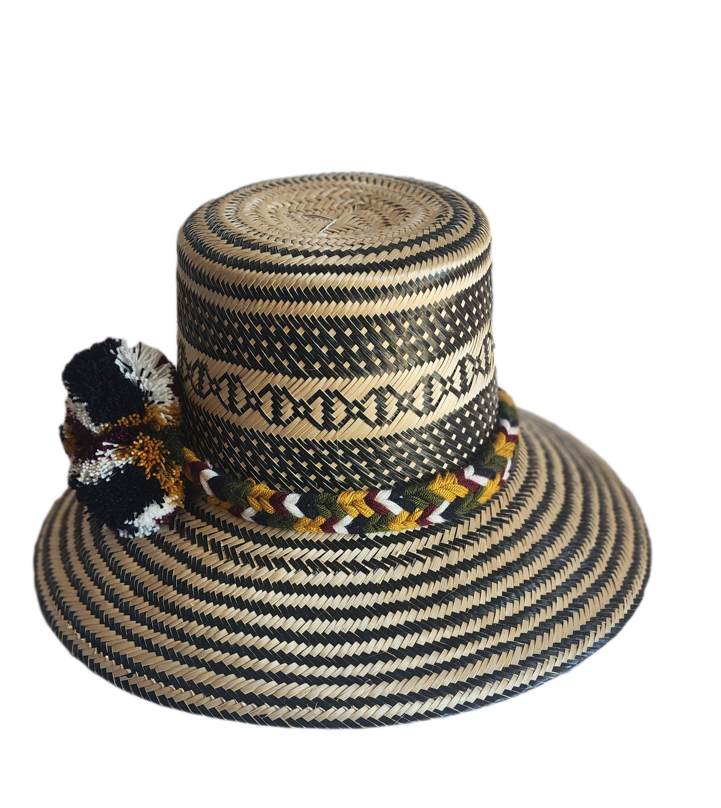 "Colorful handmade Wayuu hat crafted from Iraca palm with decorative pompoms, symbolizing wealth in Wayuu culture."
