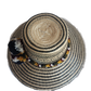 "Colorful handmade Wayuu hat crafted from Iraca palm with decorative pompoms, symbolizing wealth in Wayuu culture."
