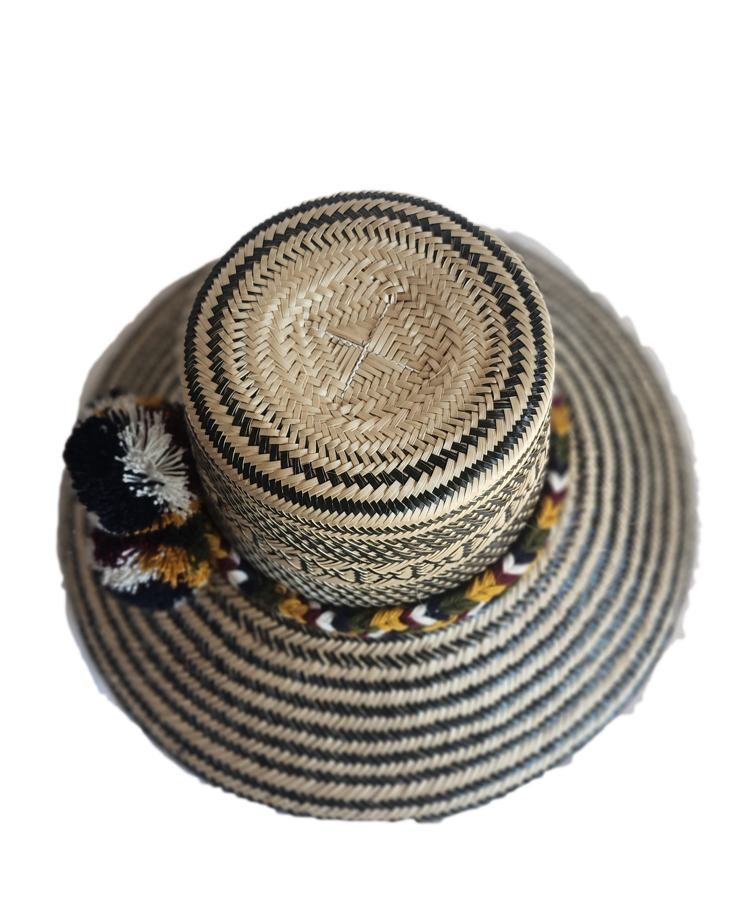 "Colorful handmade Wayuu hat crafted from Iraca palm with decorative pompoms, symbolizing wealth in Wayuu culture."