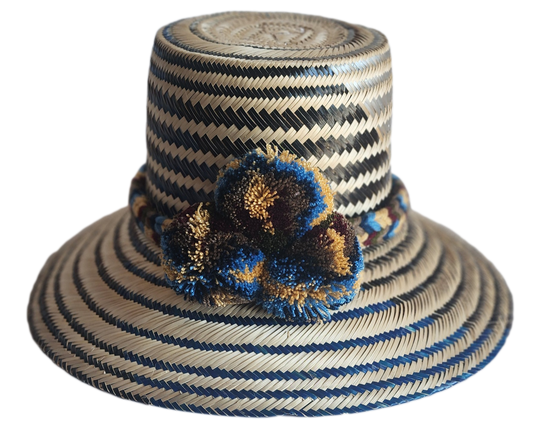 "Colorful handmade Wayuu hat from Colombia and Venezuela, woven from Iraca palm fibers with cultural pompoms."