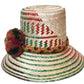 "Colorful handmade Wayuu hat from Iraca palm fiber, adorned with meaningful pompoms, showcasing vibrant, cultural design."