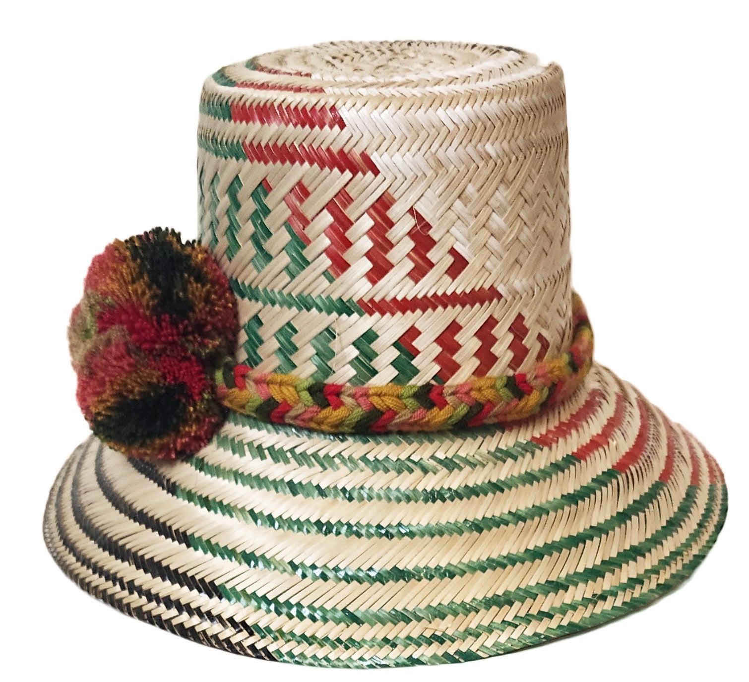 "Colorful handmade Wayuu hat from Iraca palm fiber, adorned with meaningful pompoms, showcasing vibrant, cultural design."