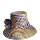 "Colorful handmade Wayuu hat from Iraca palm fibers, adorned with culturally significant pompoms, showcasing unique artisan c
