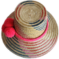 "Colorful handmade Wayuu hat from Iraca palm fibers, adorned with culturally significant pompoms, showcasing unique weaving b