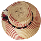 "Colorful handmade Wayuu hat from Iraca palm fibers, featuring adjustable fit and cultural pompoms, supporting Wayuu Taya Fou
