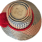 "Colorful handmade Wayuu hat from Wuitusu, crafted with Iraca palm fibers, adorned with culturally significant pompoms."