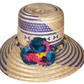 "Colorful handmade Wayuu hat with decorative pompoms, crafted from Iraca palm fibers by Wuitusu artisans."