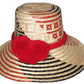 Handmade Wayuu straw hat with bold red pompoms and black-red weave

