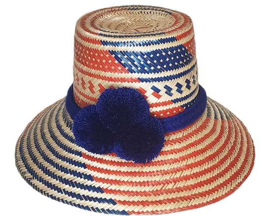 "Colorful handmade Wayuu hat with vibrant pompoms, crafted from Iraca palm fibers by Wuitusu artisans, offering sun protectio