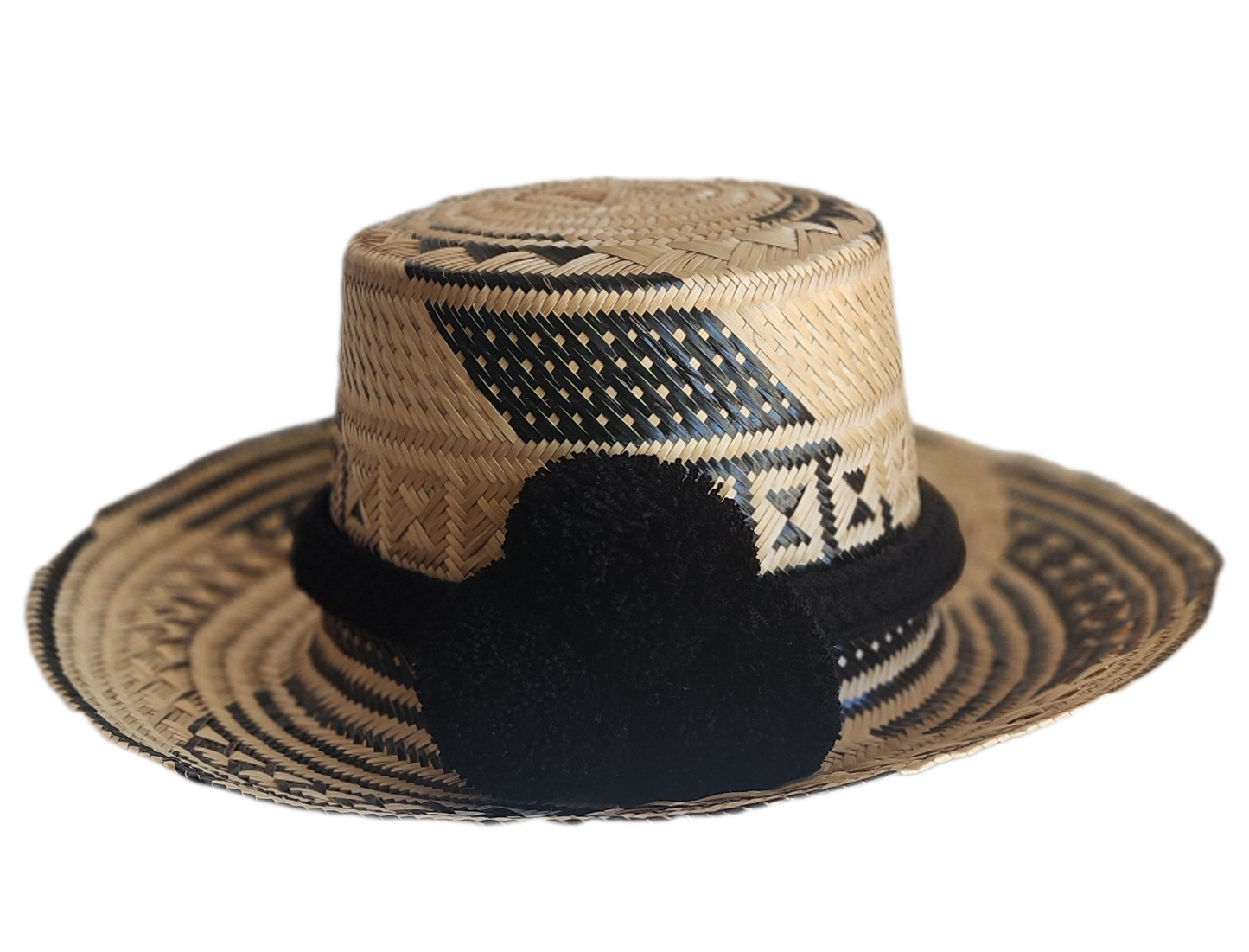 "Colorful handmade Wayuu hat woven from Iraca palm fibers, adjustable fit, adorned with culturally significant pompoms."