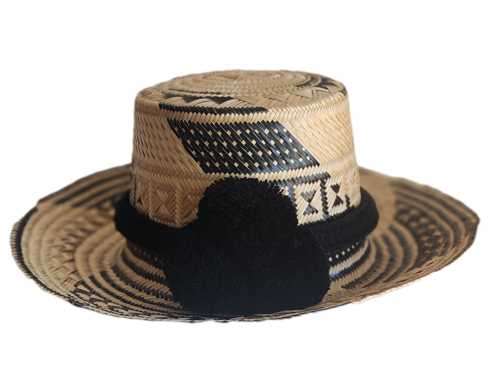 "Colorful handmade Wayuu hat woven from Iraca palm fibers, adjustable fit, adorned with culturally significant pompoms."
