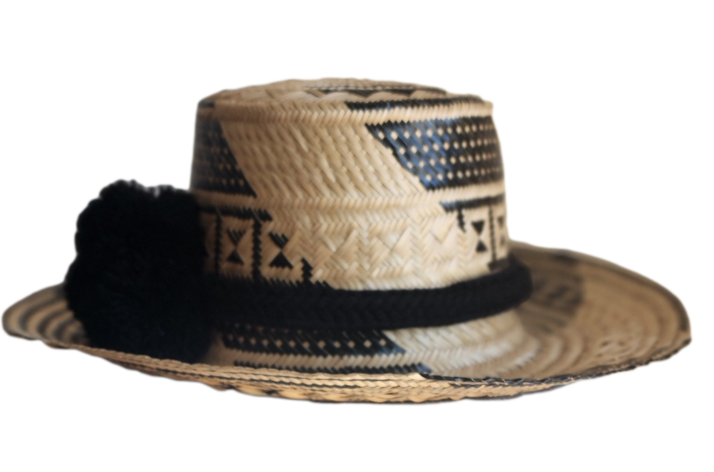 "Colorful handmade Wayuu hat woven from Iraca palm fibers, adjustable fit, adorned with culturally significant pompoms."