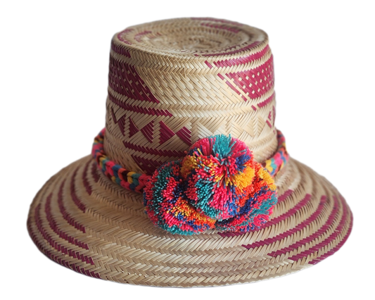 "Colorful handmade Wayuu hat woven from Iraca palm fibers, adorned with culturally significant pompoms, offering adjustable f