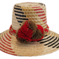 "Colorful handmade Wayuu hat crafted from Iraca palm fibers, adorned with significant cultural pom-poms for style and sun pro