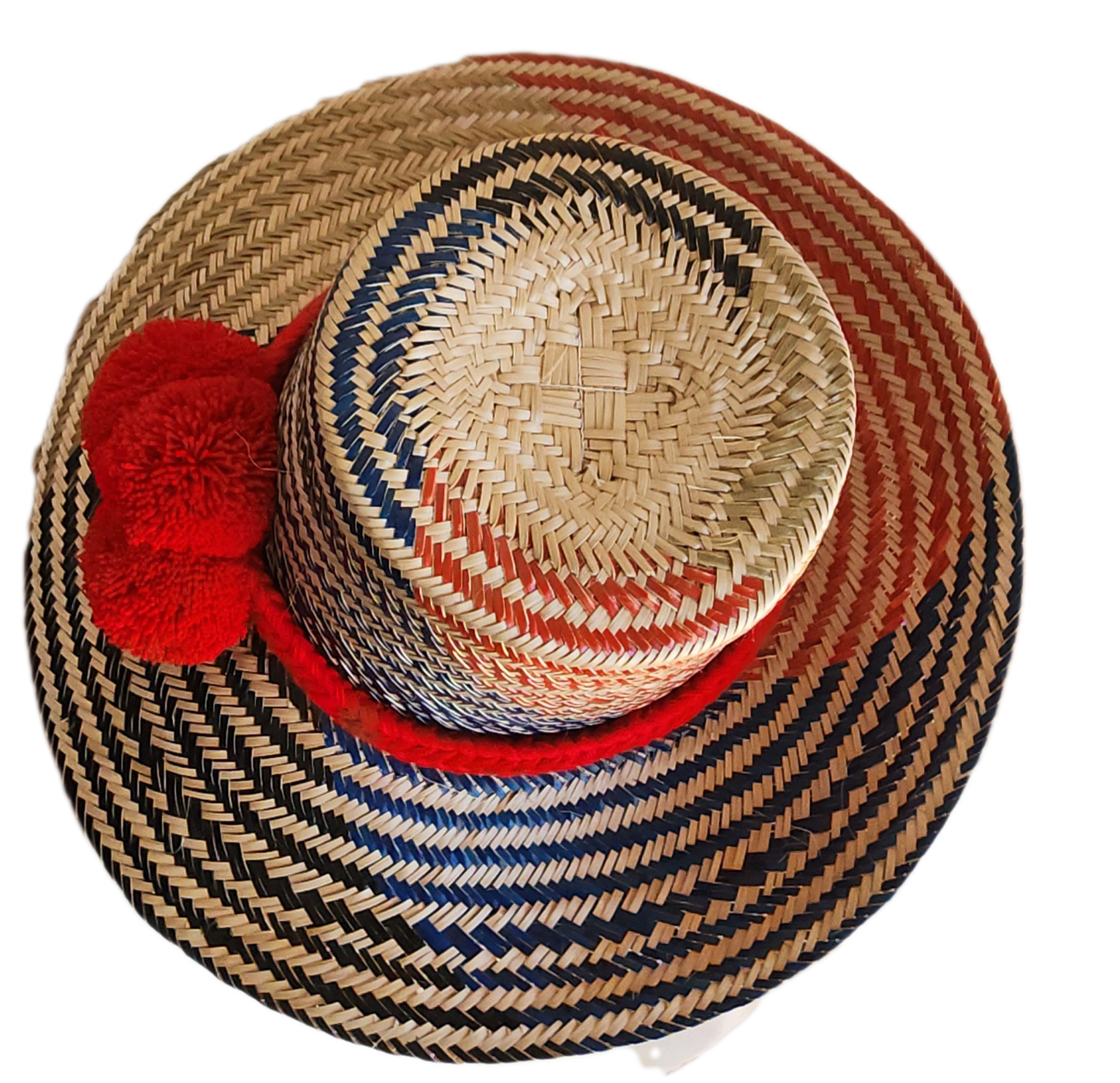 "Colorful handmade Wayuu hat woven from Iraca palm fibers, adorned with significant pompoms, adjustable for various sizes."