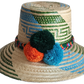 "Colorful handmade Wayuu hat woven from Iraca palm fibers, featuring decorative pompoms and offering adjustable fit."