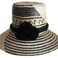 "Colorful handmade Wayuu hat woven from Iraca palm fibers, featuring adjustable fit and culturally significant pompoms."