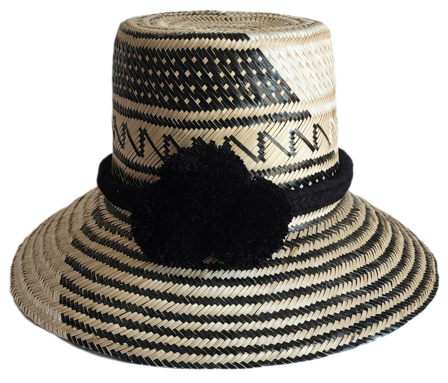 "Colorful handmade Wayuu hat woven from Iraca palm fibers, featuring adjustable fit and culturally significant pompoms."