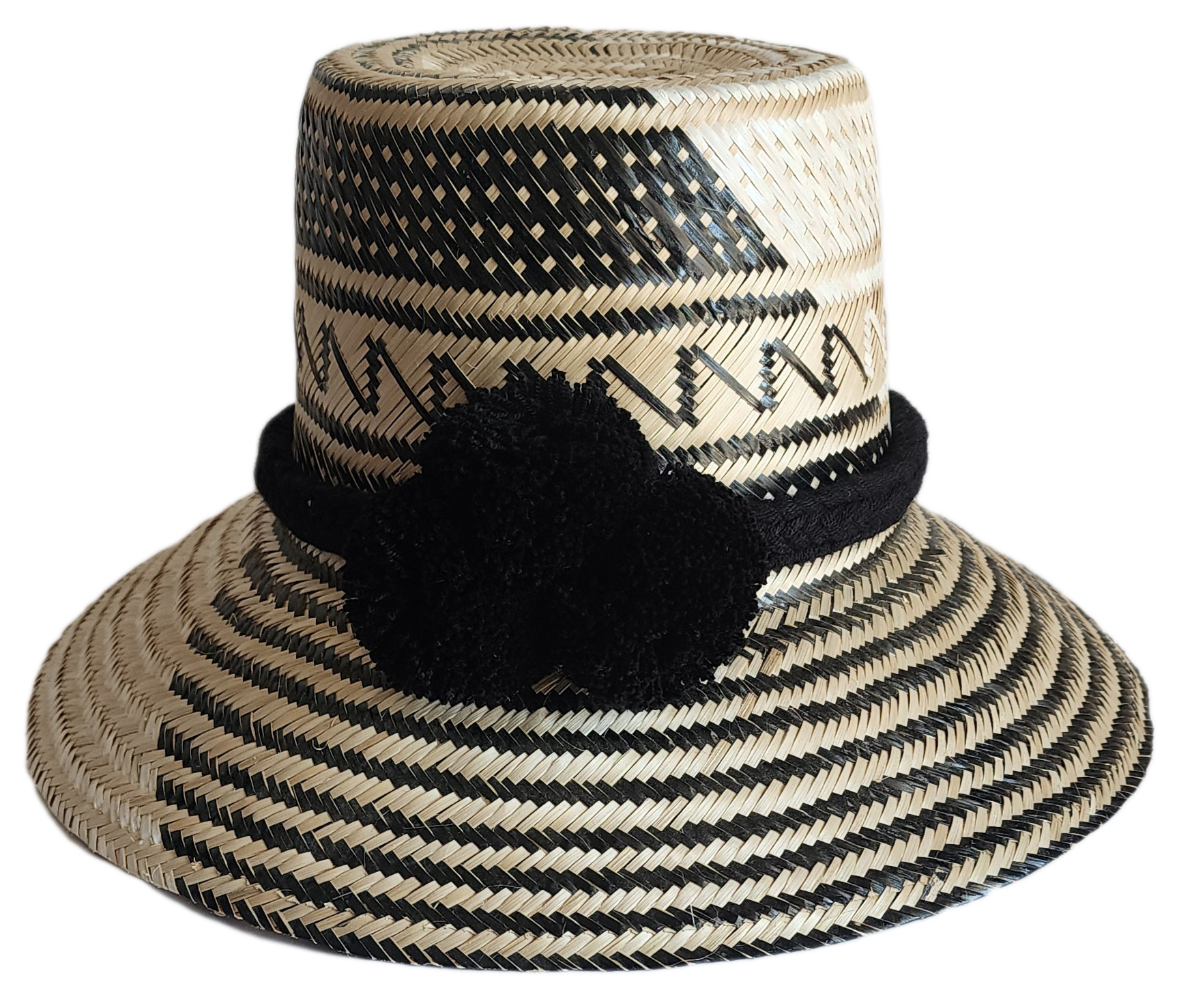 "Colorful handmade Wayuu hat woven from Iraca palm fibers, featuring adjustable fit and culturally significant pompoms."