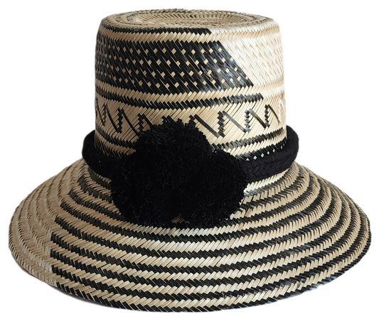 "Colorful handmade Wayuu hat woven from Iraca palm fibers, featuring adjustable fit and culturally significant pompoms."